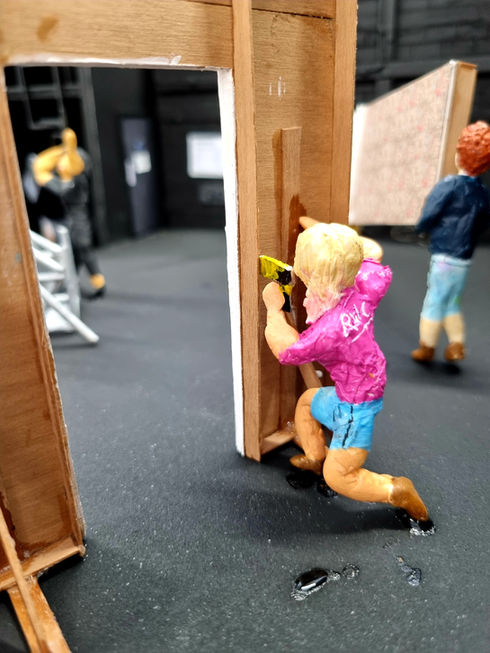 a close up of a model of a figurine building scenery on stage