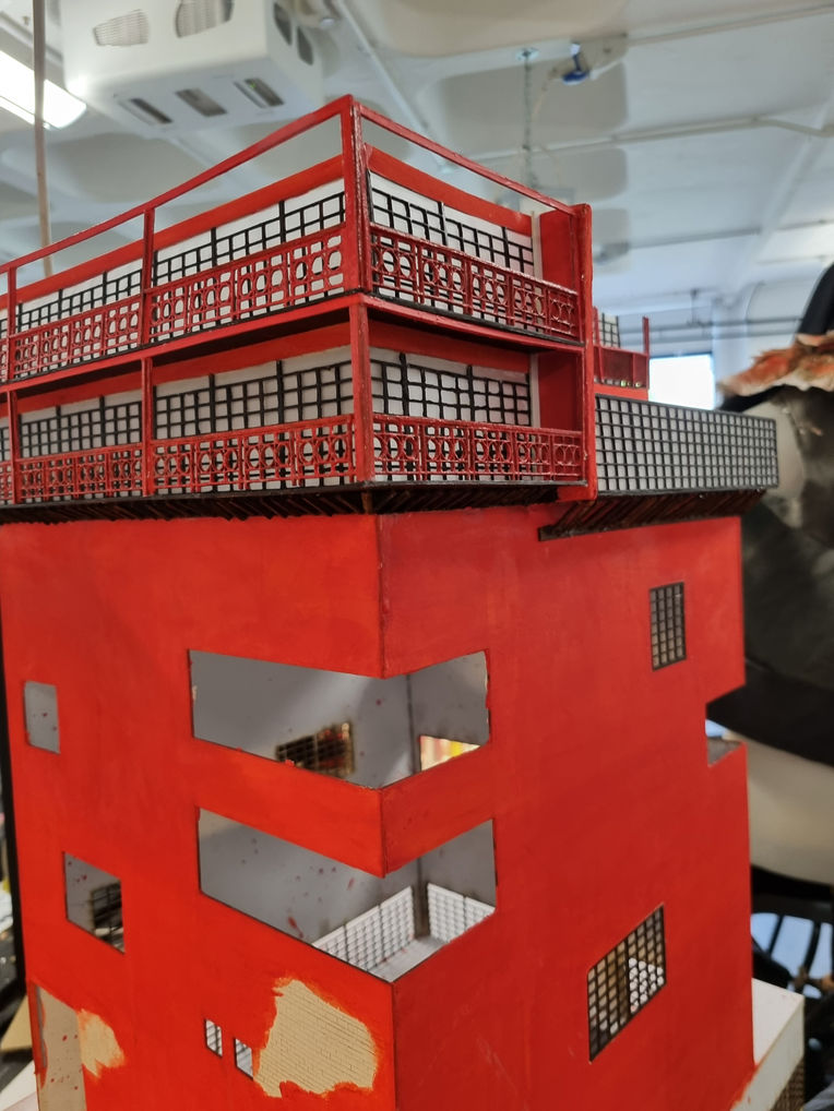 model painted red. there are holes where pieces are noticeably missing