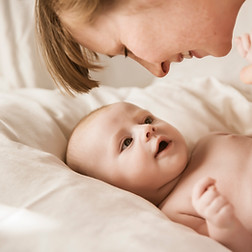 Mutter, die mit neugeborenem Baby lächelt
