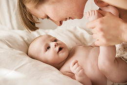 Mãe sorrindo com bebê recém-nascido