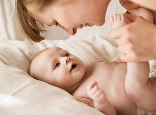 Mutter, die mit neugeborenem Baby lächelt