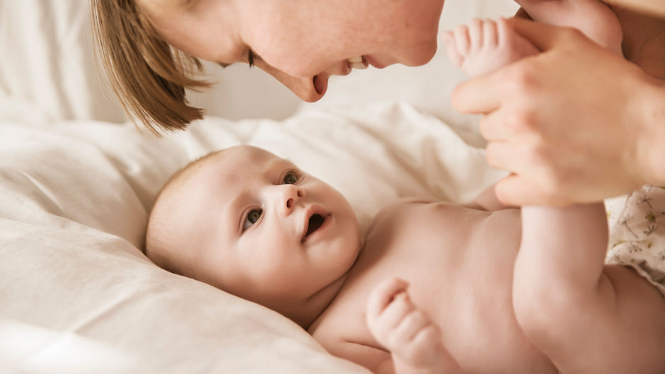 Mamá cariñosa con bebé, buscando el mejor extractor eléctrico de leche materna