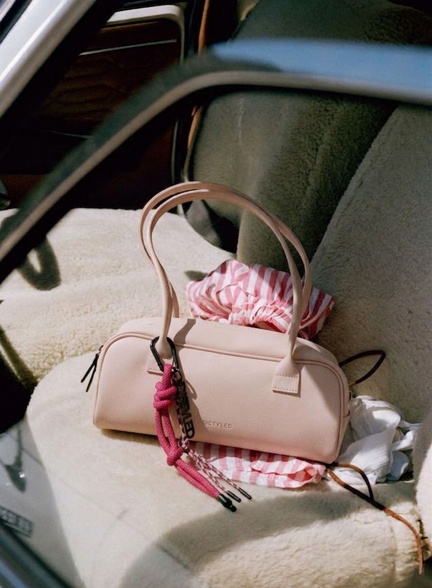 Baby pink bowling bag on drivers seat in the car in summer vibe