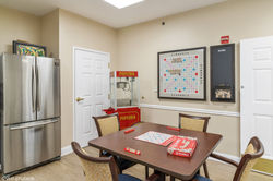 Generation Healthcare Managers community activity room with a game table and colorful wall display.