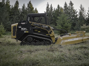 A yellow and black skid steer with heavy duty brush mower mowing tall grass
