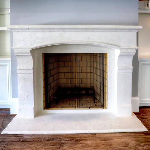 Elegant white fireplace mantel with a classic design, featuring a tiled firebox and a mesh screen, set against light cabinets