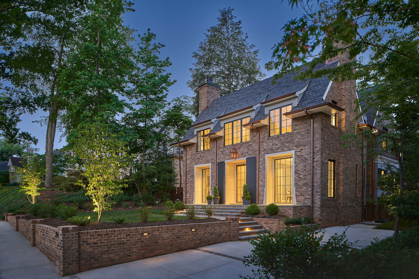 Traditional brick home featuring cast stone front door surround and window accents with symmetrical layout.