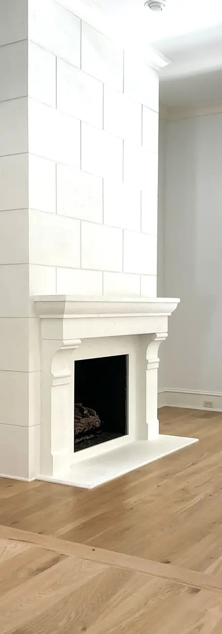 A sophisticated living space with a cast stone fireplace mantel, elegant wood flooring, and modern artwork.