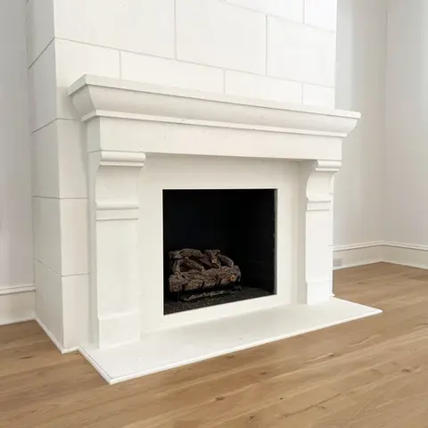 Elegant white fireplace mantel with detailed moldings on a hardwood floor, creating a cozy, stylish room focal point.