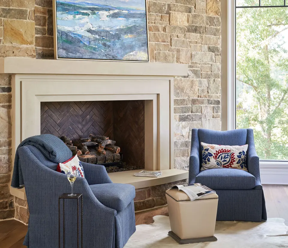 Living room sitting area featuring a contemporary stone fireplace surround in cream limestone and a stone veneer fireplace chase.