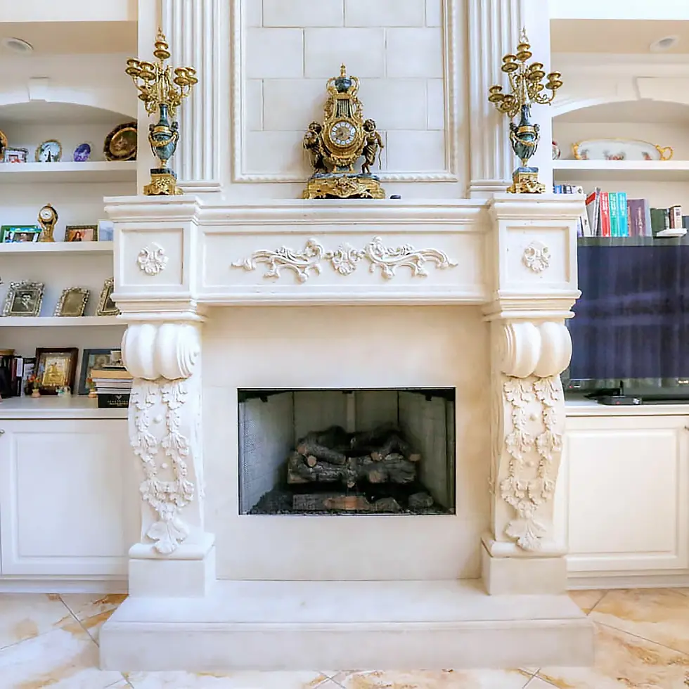 Elegant stone fireplace mantel adorned with ornate carvings, flanked by classic decor and a central antique clock.