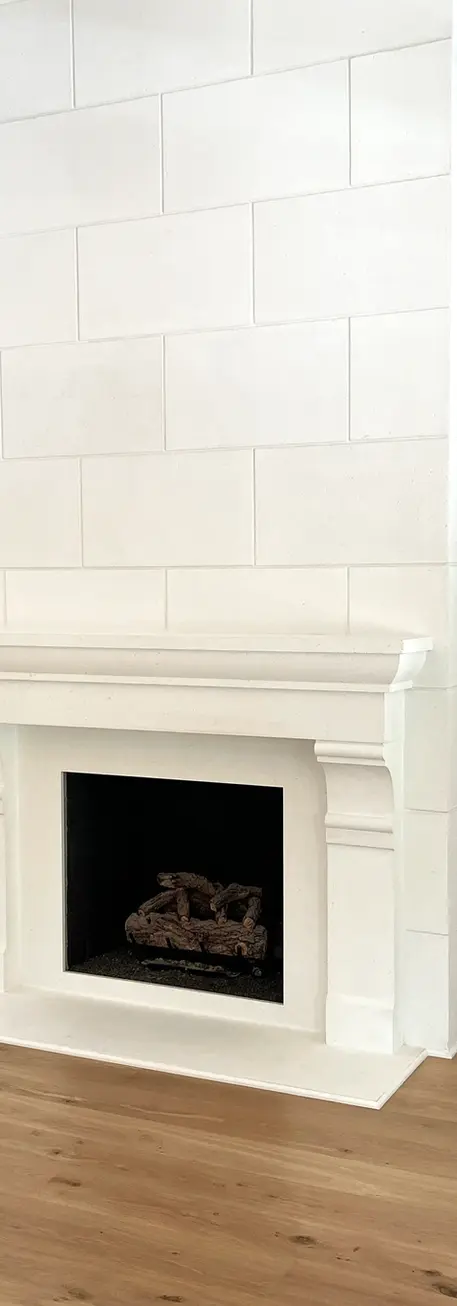Sleek stone fireplace with a modern design, stylish light fixture, and wooden flooring creates a warm, inviting living space.