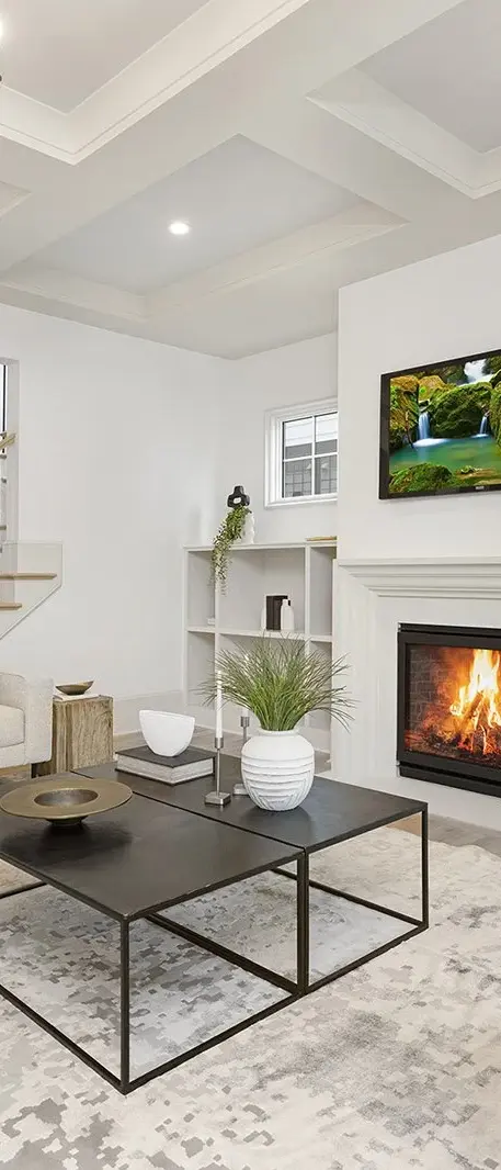 Elegant living room featuring a cozy fireplace with a sophisticated stone surround, complemented by minimalist decor.