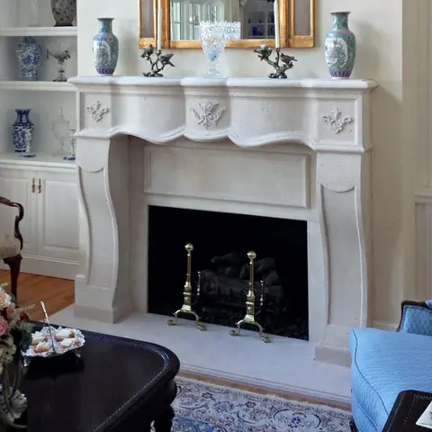 Elegant stone fireplace mantel adorned with decorative vases and a mirror, creating a classic and sophisticated living space.
