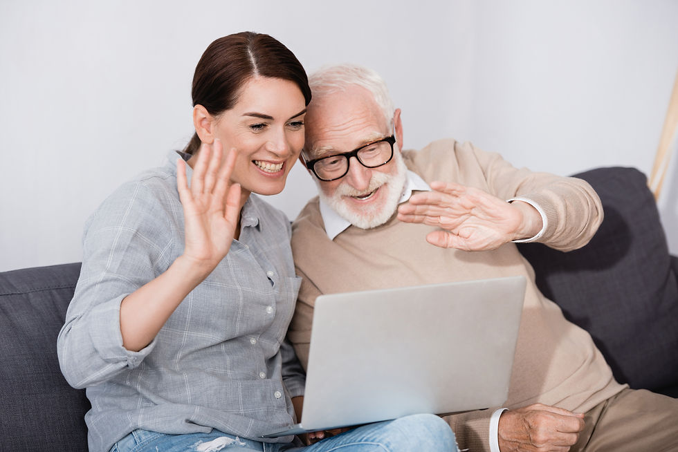 A younger woman and senior man waiving to a video call with their care manager