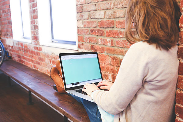 Women sitting with laptop about to make contact to enquire about menopasue services