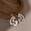 Thumbnail: Recycled silver Swell drop earrings on wooden box