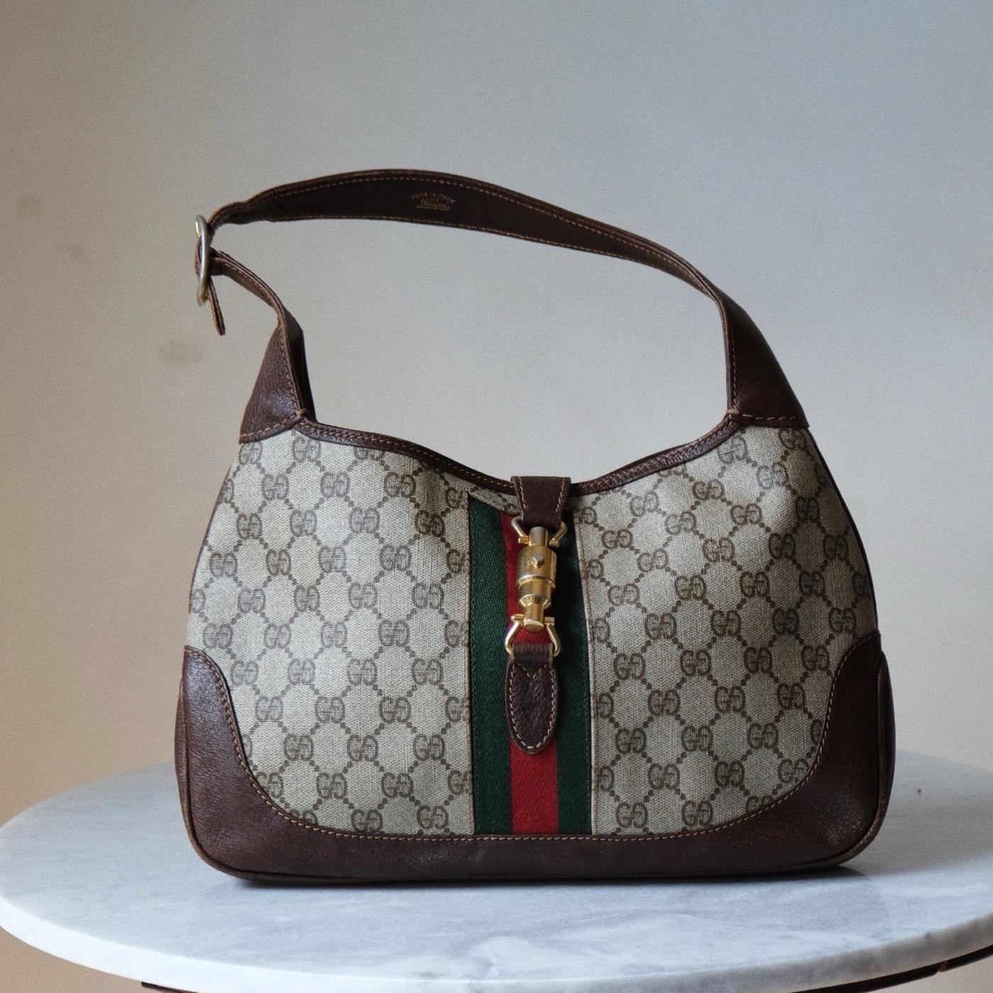 Gucci-skulderveske i GG-canvas med grønn og rød stripe og brune skinnkanter.