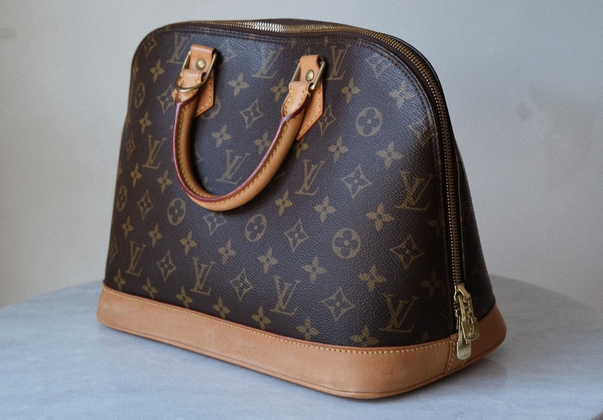 Louis Vuitton Alma med monogram, patinerte håndtak og skinnbunn.