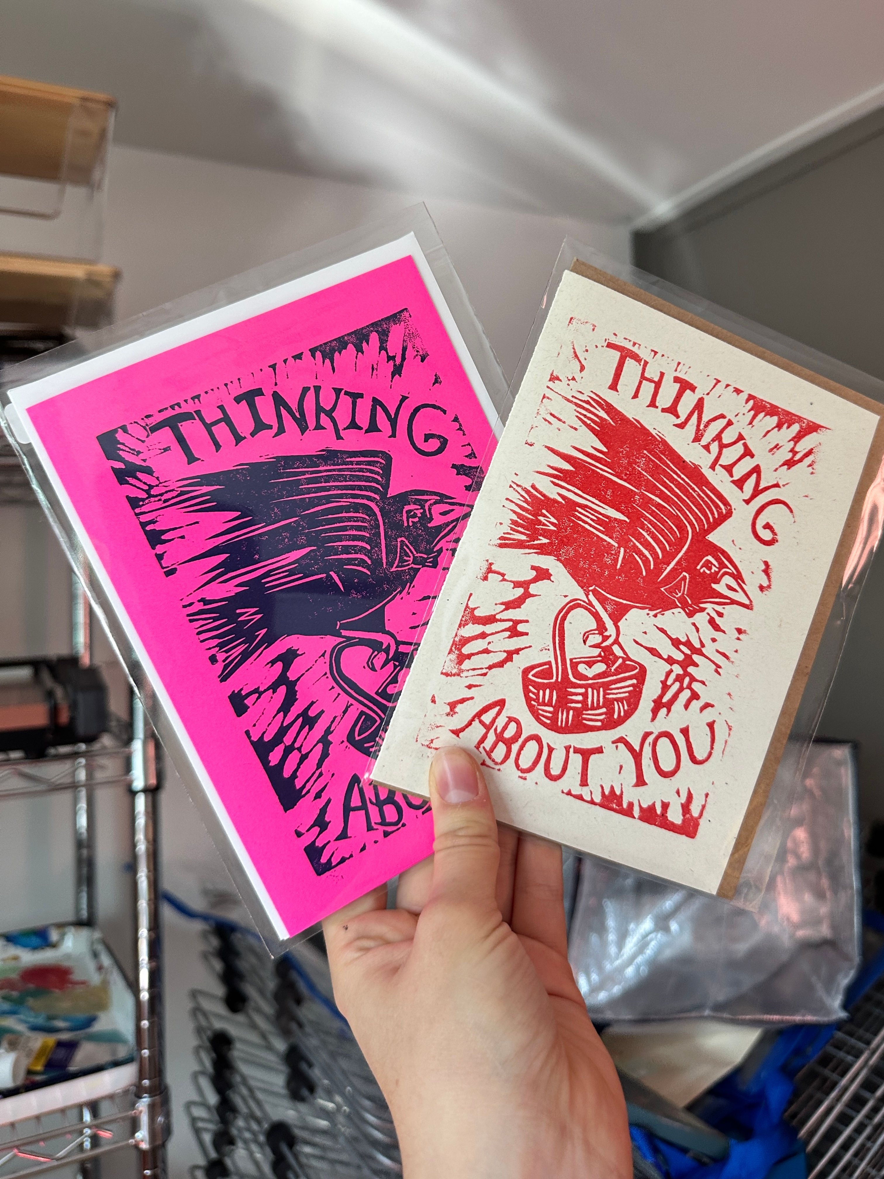 Two Thinking About You postcards in hand with bird illustrations and text.