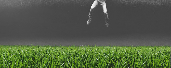 a man standing in air above the grass_ed