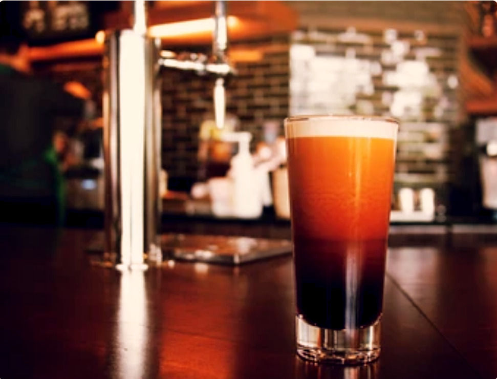 Glass of nitro cold brew on a coffee shop counter