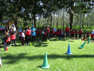 Scoring points for their teams by successfully throwing the hula hoop onto the cone