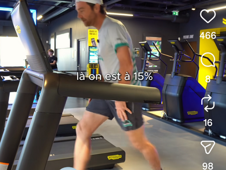 Traileur en power hiking dans une montée raide, mains sur les cuisses, buste incliné