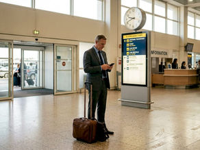 Traveler checks phone near airport arrivals