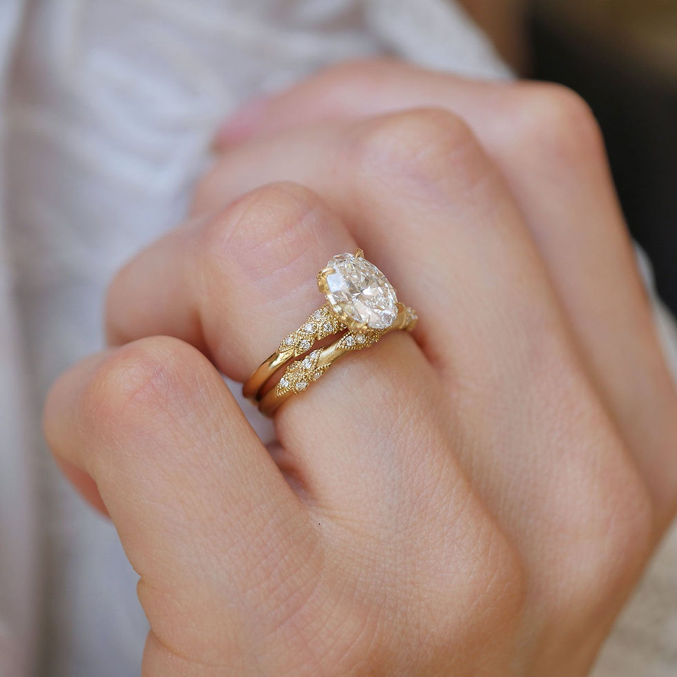 Thumbnail: Close-up of a hand wearing two nature-inspired gold rings with diamond accents.