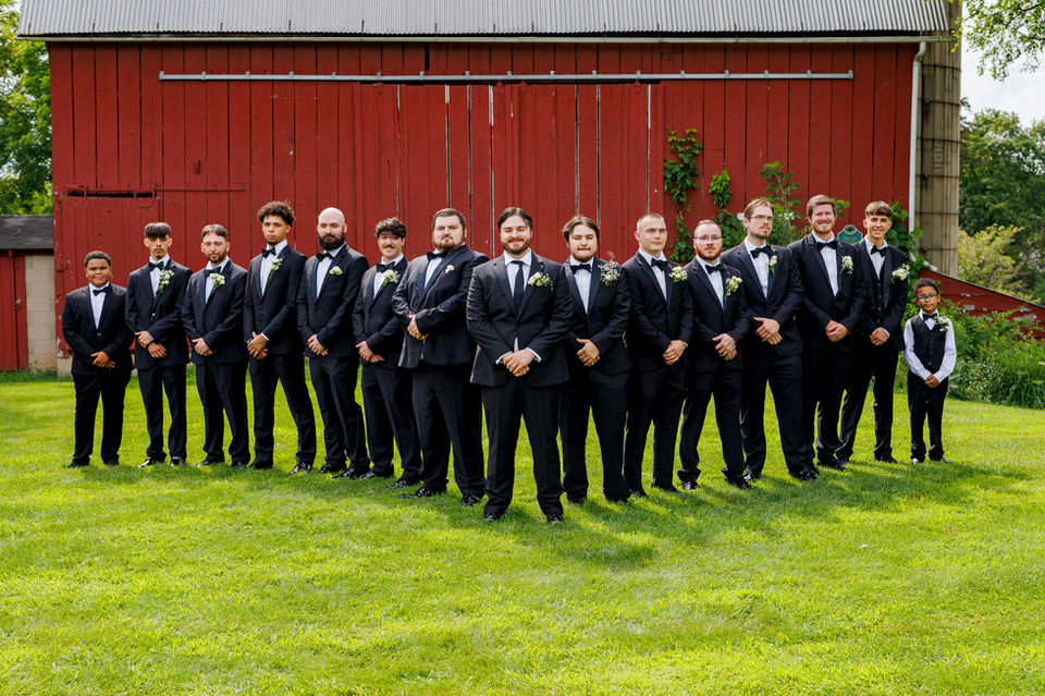 Detroit wedding photographer captures groomsmen near a red barn