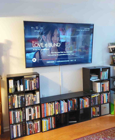 Flat-screen TV above bookshelf with wired hidden in a cable sleeve