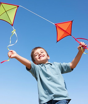 Happy and creative ten year old boy flying a kite.jpg
