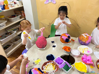 children painting paper marche with multi colour paints for easter celebration