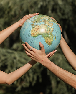 A globe being held up by four hands, going green, environmentalism