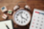 a clock a calendar a paper and pen demonstrating time management