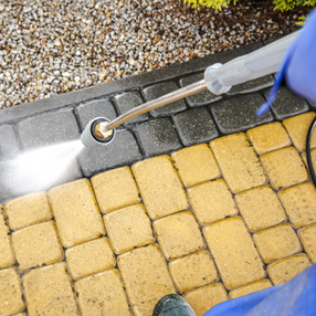 Pressure washing cleaning yellow and gray paving stones in Portugal. Clear Choice