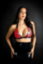 woman standing in pink latex bra and pencil skirt with hands on hips