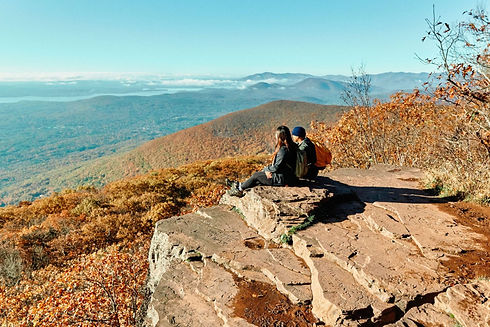Two individuals seated on a rock
