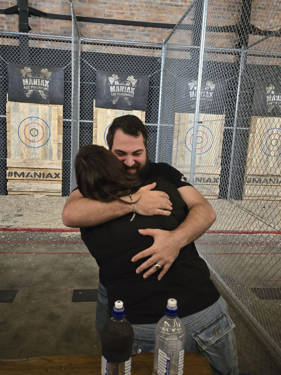 Heckler, an axe thrower, hugging their axe throwing partner at APATC