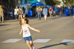 A child spins while listening to music at the Bemidji All School Reunion