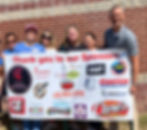 Six people holding a sponsorship banner for a fundraiser