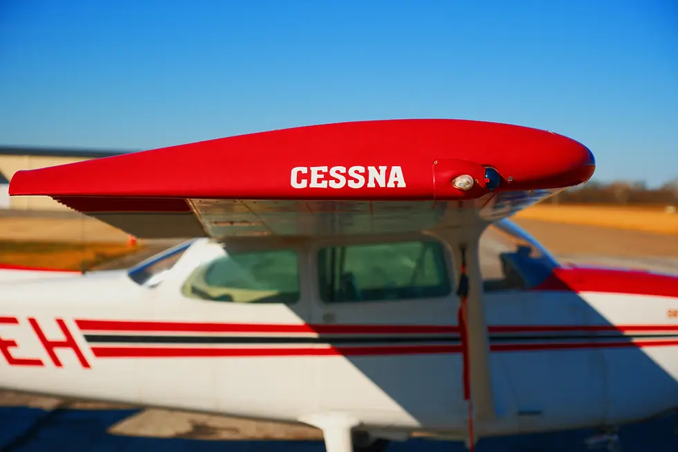 Close-up of a red and white Cessna aircraft tail on the ramp under a clear blue sky, representing first flight training for a career pilot