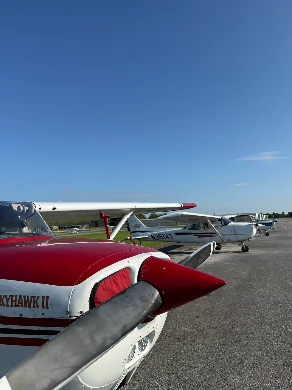 Row of Bravo Flight Training Cessna aircraft parked on the ramp at the airport