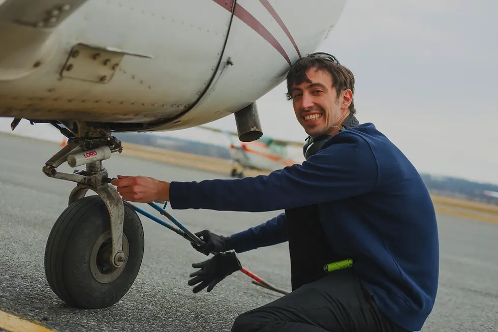Portrait of Dor Farfel, CFI flight instructor at Bravo Flight Training, working on an aircraft propeller