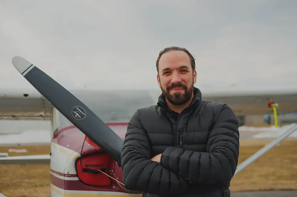 Portrait of Omar Luna, Chief Executive Officer of Bravo Flight Training, standing in front of an aircraft propeller