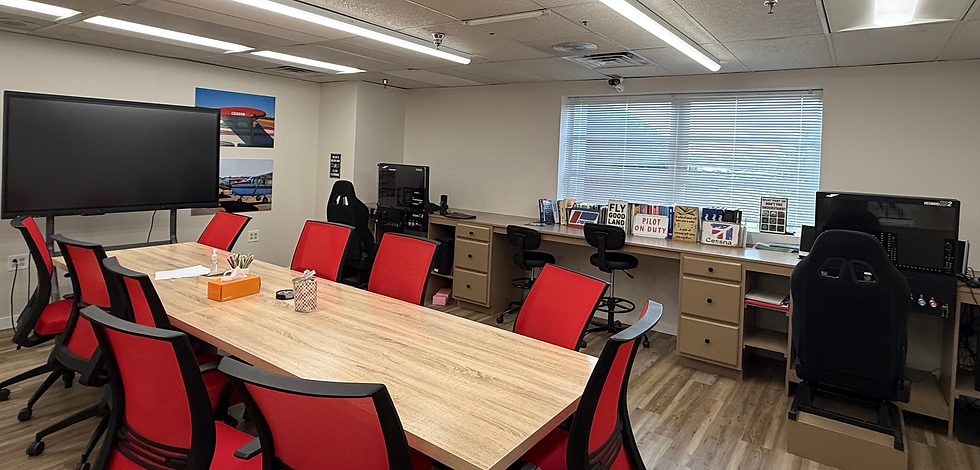 Bravo Flight Training's briefing and conference room with a large table and red chairs