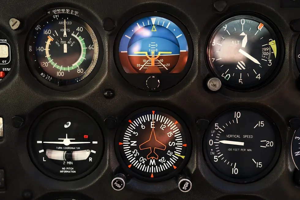 Close-up of an aircraft instrument panel showing attitude indicator, altimeter, airspeed indicator, and other flight instruments used in instrument flight training