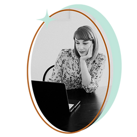 Jessica of Lumora Studio looking at laptop in black and white