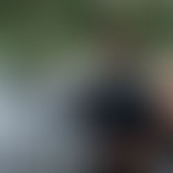 Newly-married couple looks out over an outdoor staircase patio at their guests at reception at sunset.